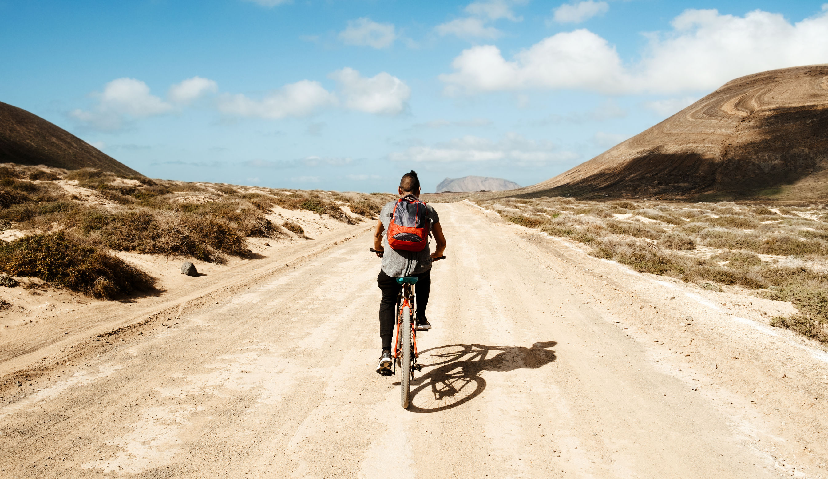 man riding a bike in La Graciosa, Canary Islands, Spain